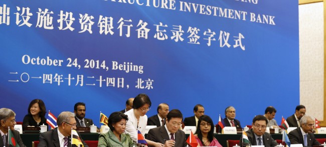 China's Finance Minister Lou Jiwei signs a document, with the guests of the signing ceremony of the Asian Infrastructure Investment Bank at the Great Hall of the People in Beijing