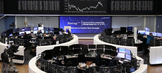 Écrans d'indices boursiers et PMI dans une salle des marchés